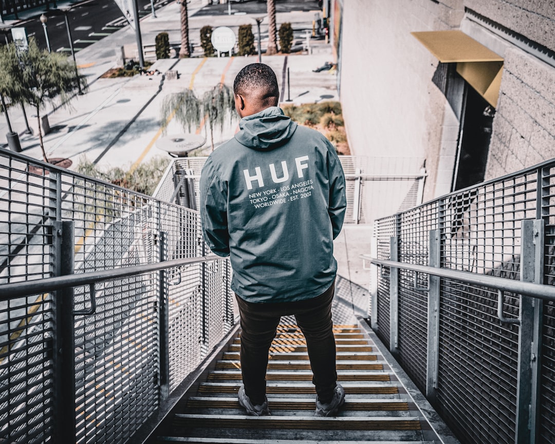 about-04 man-in-gray-and-black-adidas-hoodie-standing-on-bridge-during-daytime-yr23emqjuxi